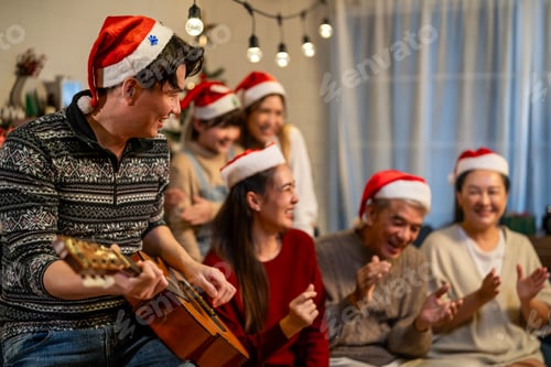 Preview: Attractive family clapping hands and singing christmas song in house.