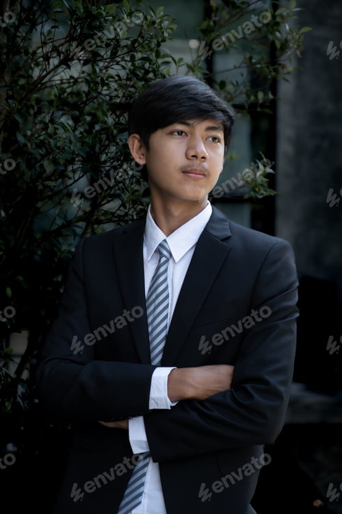 Preview: Young businessman financier investors stand with a luxurious black hotel building in the background