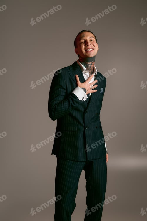 Preview: Stylish young man exudes confidence and charm in elegant suit against a muted background