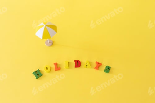 Preview: beach umbrella and holidays text on yellow summer background, vacation and travelling concept