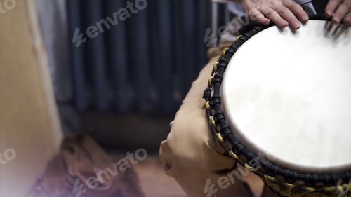 Preview: Close up of hands of a black man playing a drum. Clip. Drummer plays on small African drum, closeup