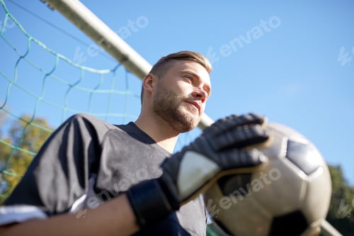 Preview: goalkeeper with ball at football goal on field