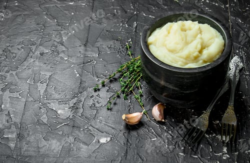 Preview: Mashed potatoes in a bowl with garlic and thyme.
