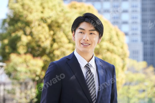 Preview: Japanese male businessman standing in the background of a tree.