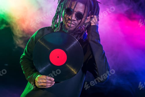 Preview: professional african american club DJ with vinyl in nightclub