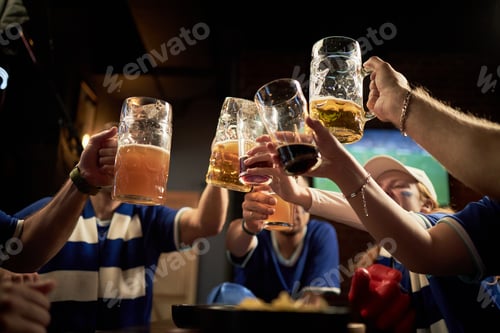 Preview: Group of Soccer Fans Toasting with Beer in Pub