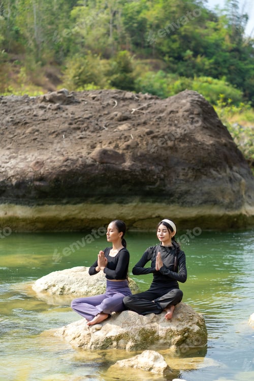 Preview: Asian Indonesian Women Meditating Peacefully by the River in Nature