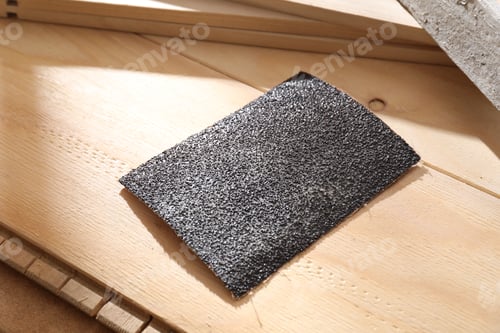 Preview: One coarse sandpaper on wooden planks, closeup