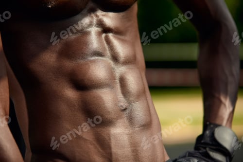 Preview: Male muscular belly, close-up, black man's abdominal relief.