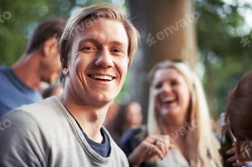 Preview: Portrait of a happy young man enjoying an outdoor festival with his friends
