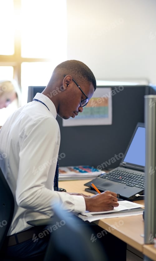 Preview: Shot of a young businessman working at his desk in an office