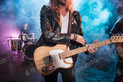 Preview: Cropped shot of electric guitar player playing hard rock music on stage