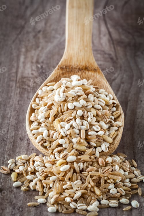 Wooden Spoon Full of Pearled Barley on Table