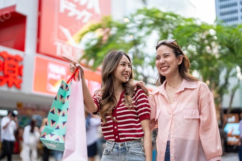 Preview: Asian young women shopping goods outdoor in shopping street at night.