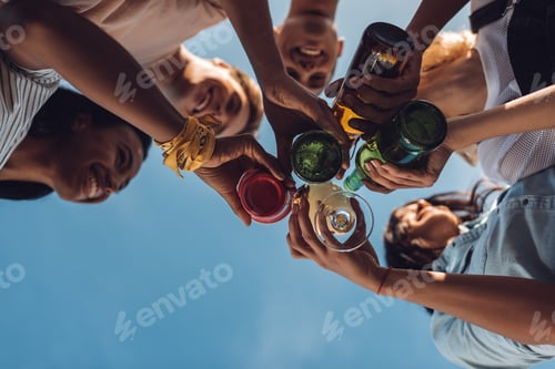 Preview: bottom view of people clinking with alcohol bottles and glasses