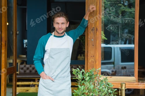 Preview: Portrait of smiling waiter standing with hand in pocket