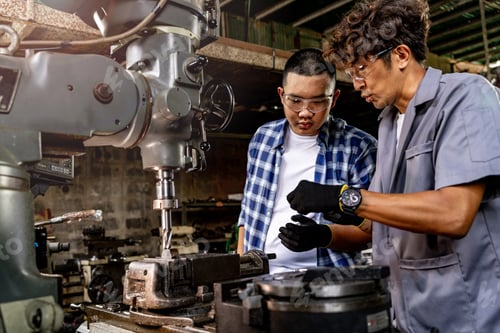 Preview: Professional worker near drilling machine on factory.