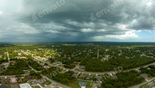 Preview: Dark stormy clouds forming on gloomy sky before heavy rainfall over suburban town area