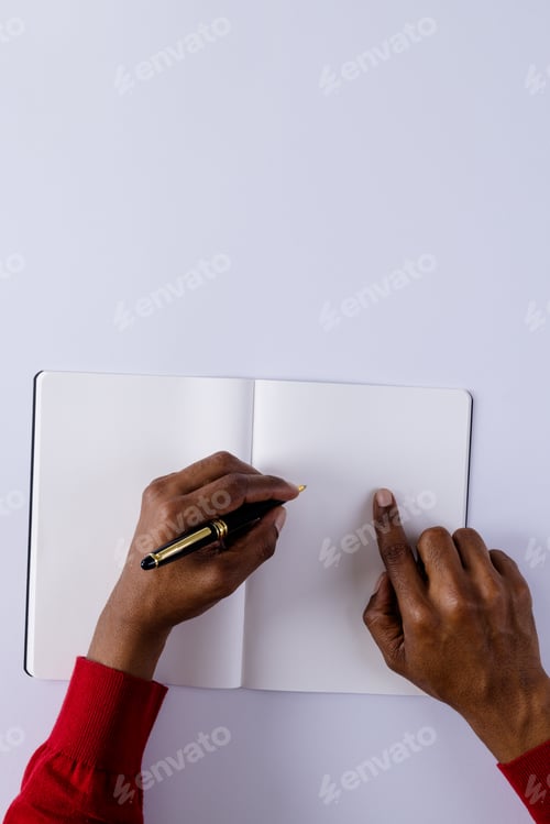 Preview: Hands of biracial man holding pen, writing in notebook with copy space on white background