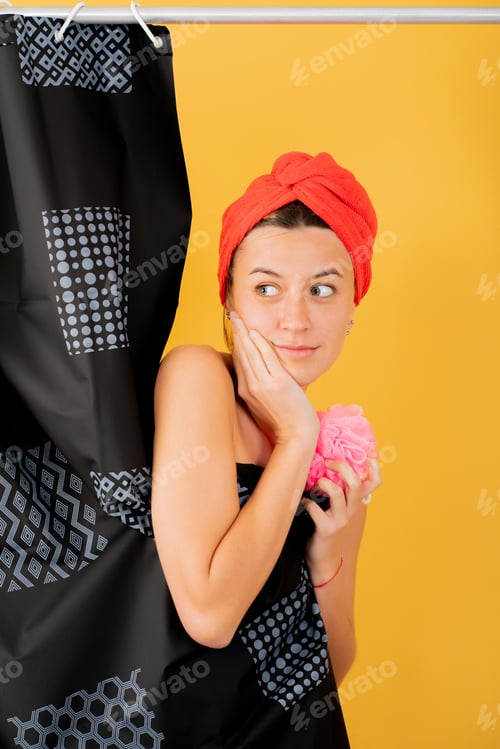Preview: Young woman hiding behind shower curtain.