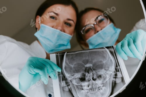 Preview: First-person view. Professional dentist doctor looks at x-ray picture of patient's jaw.