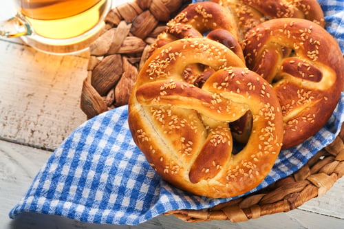 Preview: Bavarian pretzels and glass of lager beer. Oktoberfest food menu, traditional salted pretzels over o
