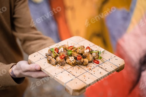 Preview: Fried mussels with chili, garlic, sesame, and herbs, served by waiter on board.