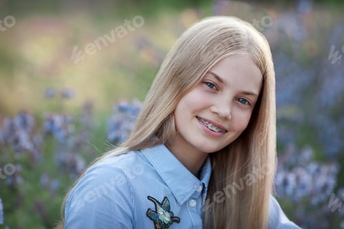 Preview: beautiful teen girl with braces on her teeth smiling. portrait of blonde model