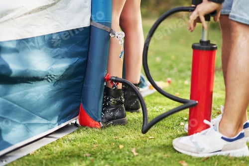Preview: Young nice couple having fun on camping setting up tent