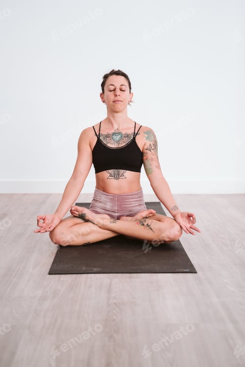 Preview: young tattooed woman practicing yoga sport at the gym. Healthy lifestyle