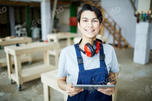 Preview: Smiling female carpenter with tablet