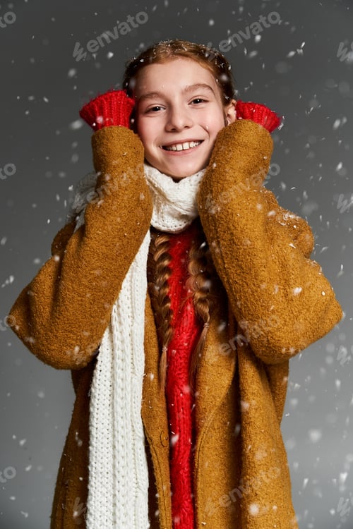 Preview: A joyful child enjoys a snowy winter day in cozy attire with a bright smile on her face