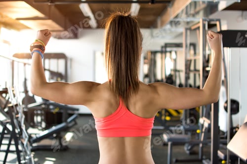 Preview: Back view of a sporty woman posing in gym. Close up.