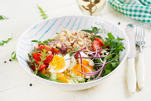 Preview: Breakfast oatmeal porridge with boiled eggs, tomatoes and red onions.