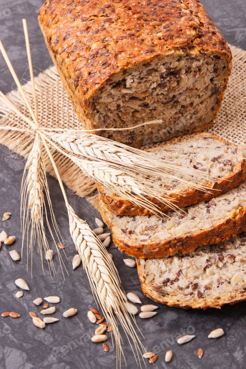 Preview: Wholegrain bread for breakfast, ingredients for baking and ears of rye or wheat grain