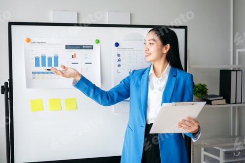 Preview: A woman in a blue suit is standing in front of a white board with a presentation