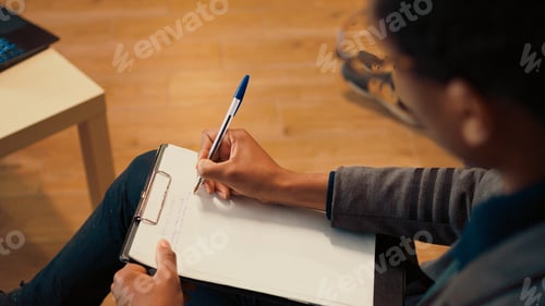 Preview: Psychology counselor taking notes on clipboard at therapy session