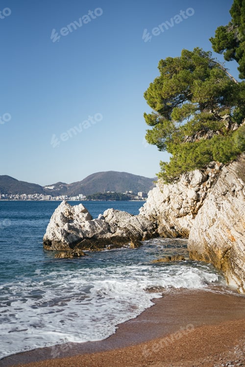 Preview: Sea waves roll on the sandy shore near the sheer cliffs