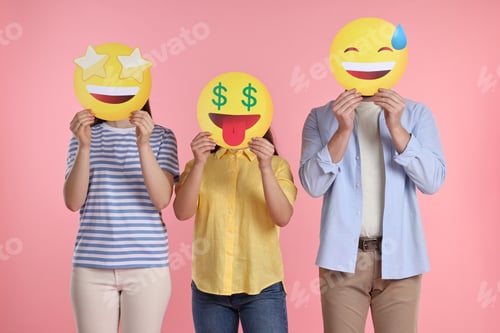 Preview: People covering faces with emoticons on pink background