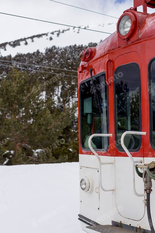 Preview: red train locomotive in the mountains. blue and cloudy sky with snow.Winter season.Transport