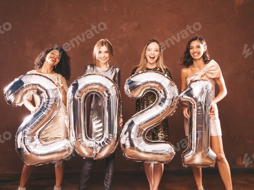 Preview: Portrait of four young stylish women holding silver 2021 balloons