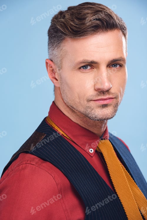 Preview: portrait of handsome stylish man in formal wear looking at camera isolated on blue