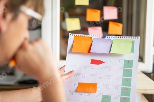Preview: Woman planning agenda with calendar and sticky notes
