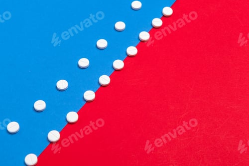 Preview: White medical pills on a two color red and blue background