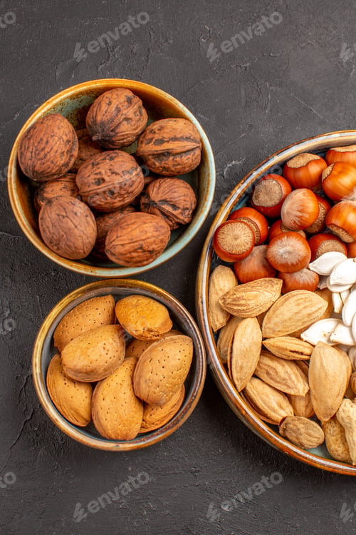 Preview: top view nut composition walnuts and other nuts on grey background many walnut snack nut
