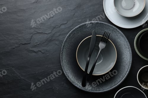Preview: Set of clean tableware on black table, flat lay. Space for text