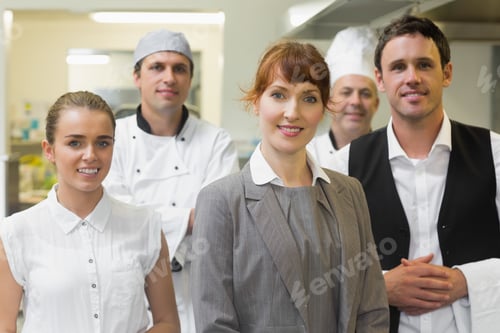 Preview: Young Female Manager Posing In A Modern Kitchen With The Staff