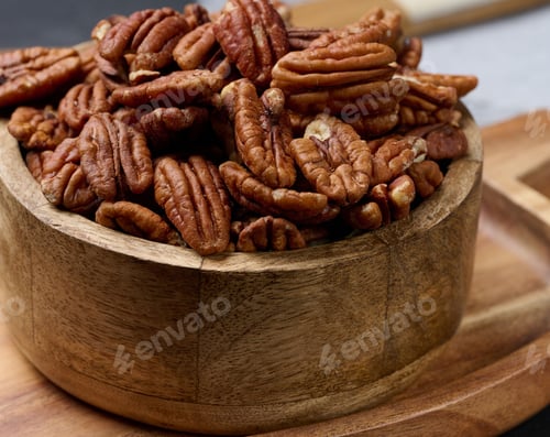 Preview: Shelled pecans in a round wooden plate