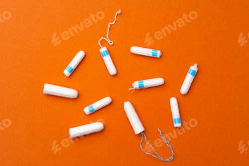 Preview: Medical female tampons on orange background top view