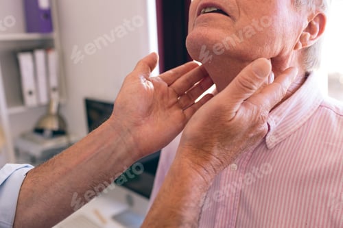 Preview: Mature male doctor checking senior mans neck in clinic at retirement home